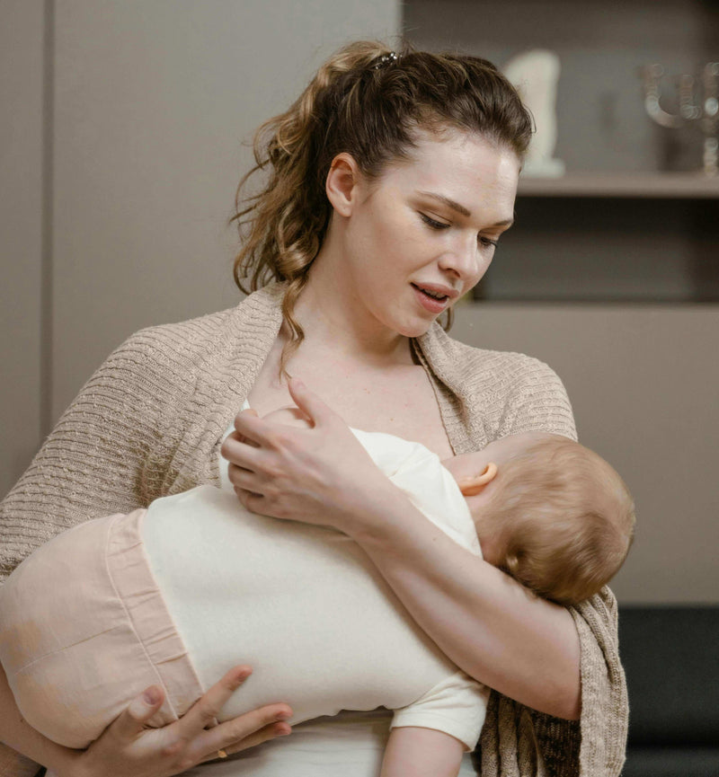 Mom bonding with her baby while using wearable breast pumps for modern moms, showcasing convenience and care.